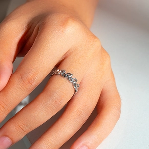 Close-up of a silver stainless steel hollow leaf ring shown on a model hand