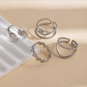 Set de cuatro anillos de acero inoxidable plateado con diseño de manos y hojas caladas