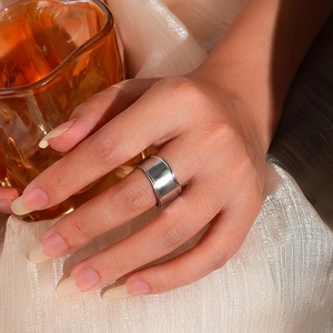 Anello largo in acciaio inossidabile a trama irregolare sulla mano della modella