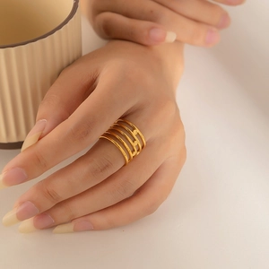 Vue macro d'une bague multicouche dorée portée à la main avec de petits disques décoratifs