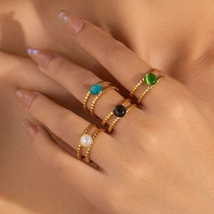 Detalle de anillos de doble capa con cuentas y piedras naturales de colores en la mano