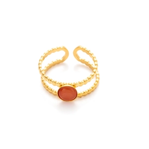 Detalle del anillo de doble capa de acero dorado con piedra natural ovalada roja