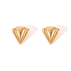Macro-detail van gouden vintage geometrische oorbellen met verticale 3D-ribbels