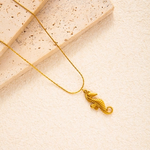 Detailed close-up of golden seahorse pendant necklace with intricate texture