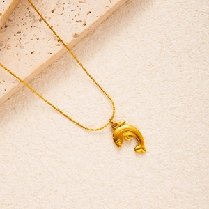 Minimalist golden stainless steel seahorse pendant necklace on stone background