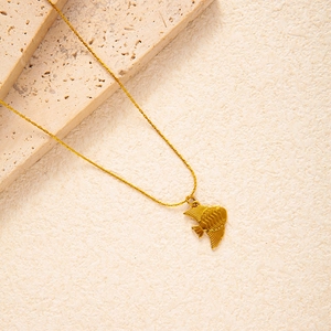 Detailed view of golden fish pendant with textured scales on a twisted titanium steel chain