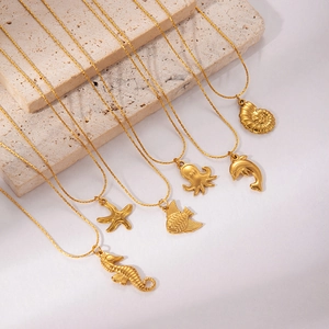 Minimalist 18K gold plated stainless steel sea animal necklaces on beige stone props