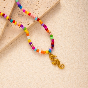Detail einer bunten Regenbogenperlenkette mit einem strukturierten goldenen Seepferdchen