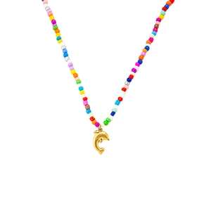 Detalle de un collar de cuentas de colores con un colgante de delfín dorado estilo playero