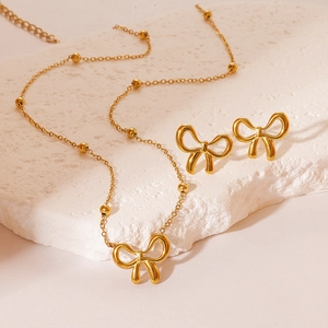 Golden stainless steel bow jewelry set with beaded chain necklace and stud earrings