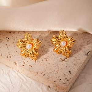 Detail view of 18k gold plated floral pearl earrings on elegant silk background