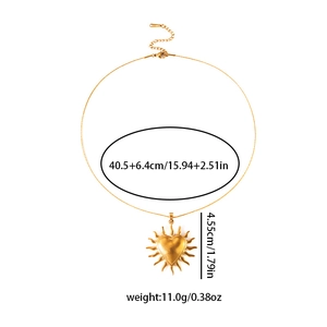 Dettaglio del ciondolo a cuore con raggio di sole dorato con misure e tag in acciaio
