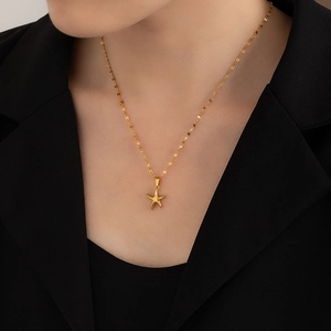 Close-up of golden starfish pendant necklace on female model with sleek metal finish