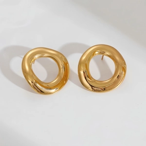 Detail van getextureerde gouden onregelmatige ronde oorringen met spiegelglans