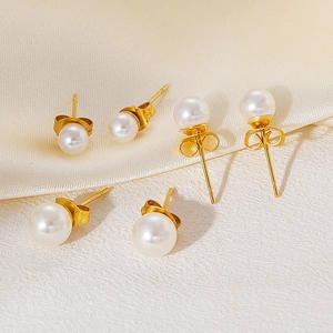 Detailopname van drie paar elegante pareloorbellen met goudkleurige afwerking