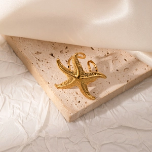 Detailed macro shot of a golden starfish ring featuring textured sea life patterns
