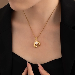 Close-up of elegant 18K gold plated necklace with a round pearl on a female model