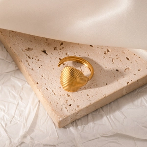 Detailed macro view of gold shell texture ring on premium elegant fabric background
