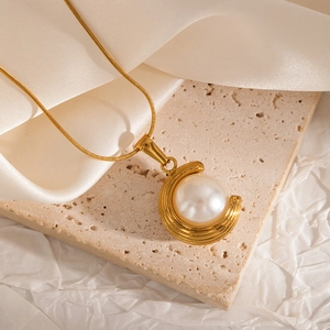 Macro view of 18K gold plated stainless steel necklace featuring a round white pearl pendant