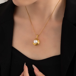 Detail of 18K gold-plated stainless steel crescent moon pearl pendant necklace on model