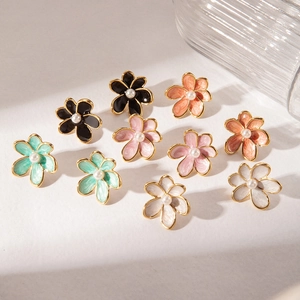 Detailed flat lay of colorful enamel flower earrings with gold edges and pearl centers