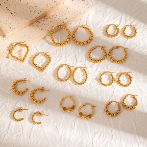 Detailed flat lay of diverse 18k gold plated stainless steel hoop earrings on white fabric