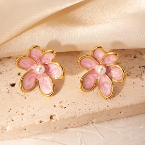 Elegant gold-plated flower stud earrings with pink enamel and pearl on a silk background