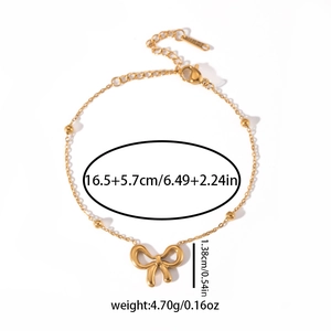 Detailed view of a gold bowknot charm bracelet with metallic beads and adjustable lobster clasp