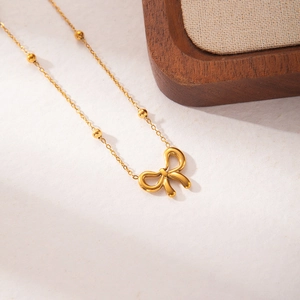 Elegant gold bow pendant necklace with beaded chain for women in stainless steel