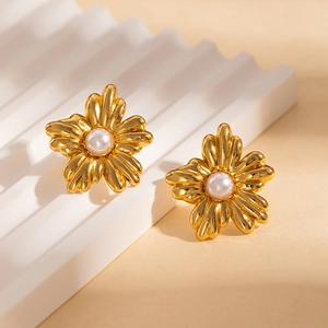 Vue détaillée des boucles d'oreilles fleur vintage dorées avec perle et texture striée