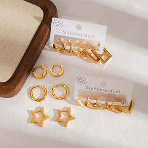 Golden stainless steel earring set featuring round and star shapes on a display card