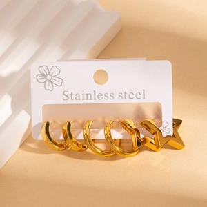 Detailed view of polished gold stainless steel hoop and star earrings set on display card