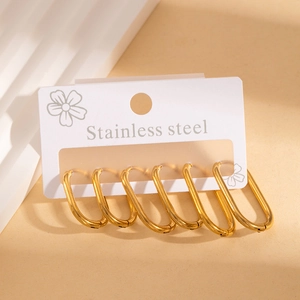 Three pairs of polished gold stainless steel U-shaped earrings on a stylish display