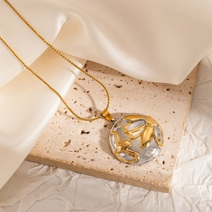 Macro shot of a gold necklace with a floral relief pendant on a beige satin background