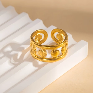 Dettaglio macro di un ampio anello dorato in acciaio inossidabile con motivi a conchiglia