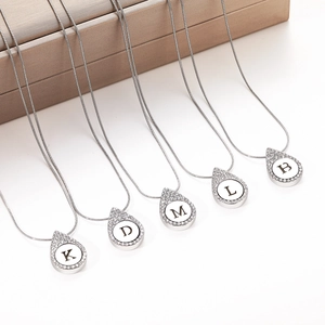 Silver teardrop necklace set with crystal inlaid letters and sleek snake chain