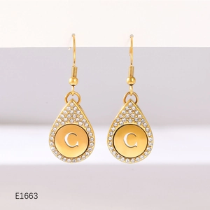 Detail view of gold teardrop earrings with letter C engraving and zircon pavé setting
