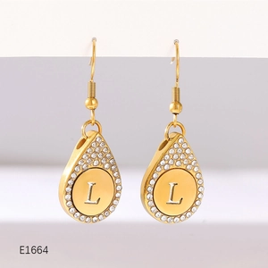 Detailed close-up of gold water-drop earrings with letter L and white zircon stones