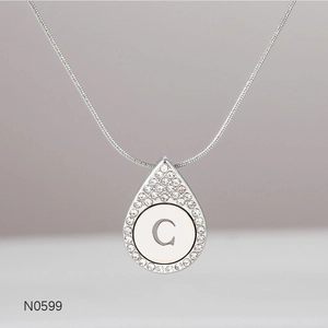 Close-up of silver letter C pendant with sparkling rhinestones on a snake chain