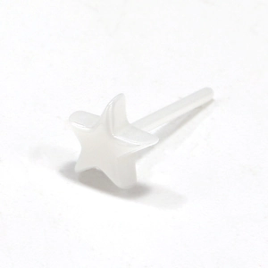 Detalle de un pendiente de estrella en cerámica blanca con diseño geométrico sobrio