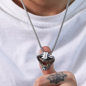 Dettaglio del ciondolo maschera Hannya giapponese con finitura bicolore argento e oro su catena