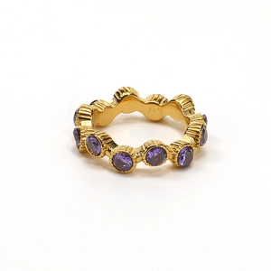 Detalle de anillo dorado con piedras púrpuras circulares y textura retro elegante