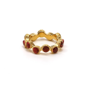 Vista detallada de un anillo dorado con brillantes piedras rojas circulares