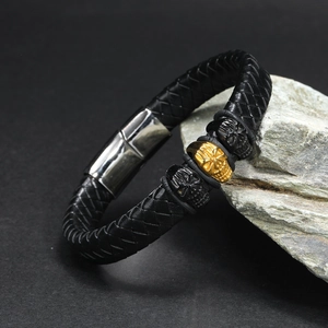 Detailansicht eines schwarzen Lederarmbands mit drei detaillierten Totenkopf-Perlen und Verschluss