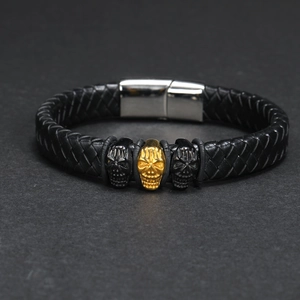 Nahaufnahme eines Herren-Lederarmbands mit goldenen und schwarzen Totenköpfen