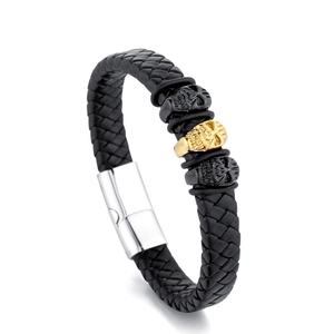 Detail eines schwarzen Lederarmbands mit goldenem Totenkopf und Magnetverschluss
