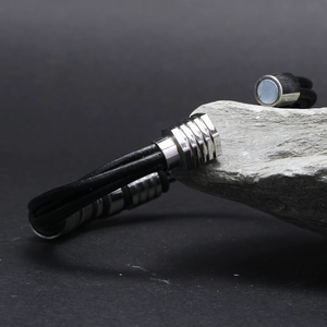 Gros plan du fermoir magnétique en acier inoxydable sur bracelet en cuir tressé noir