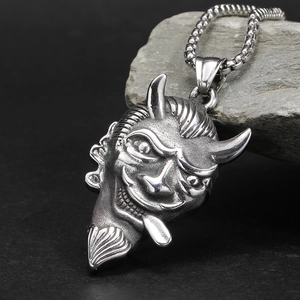 Macro shot of gothic silver bull demon pendant on rugged grey stone background