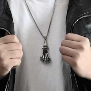 Close-up of punk ghost claw skull pendant with square bead chain on a male model