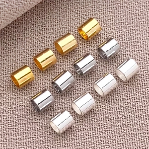 Makroansicht von 18K Gold und Silber zylindrischen Abstandsperlen für DIY Schmuckherstellung